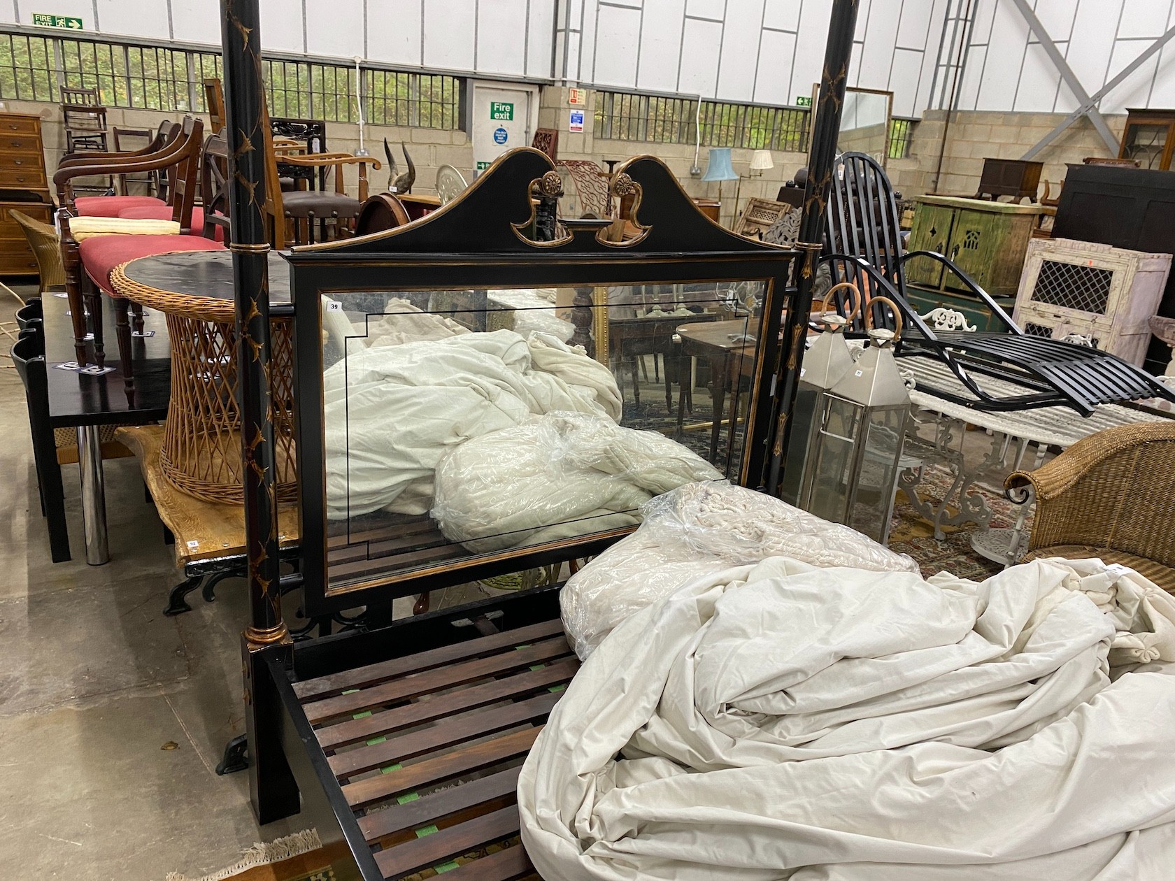 A reproduction black painted four poster bed frame with mirrored headboard, width 170cm, length 210cm, height 250cm